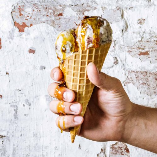 Hand holding cone of ice cream