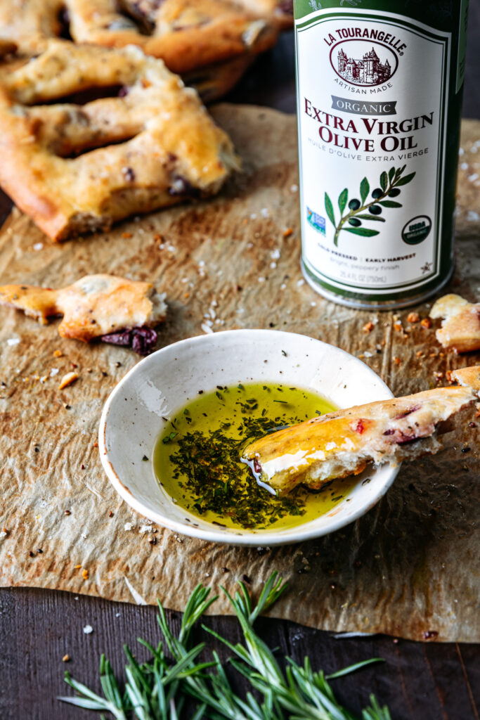 Torn piece of Fougasse dipped into olive oil
